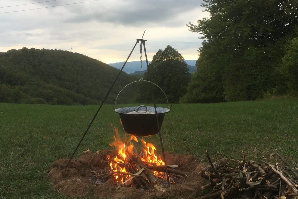 Ett gäng barn står med händerna uppsträckta och tittar mot solnedgången. De ser ut som svarta silhuetter mot den blå och gula himlen.